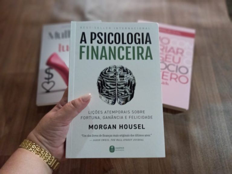Livro A Psicologia Financeira, de Morgan Housel, sendo segurado na mão durante a leitura