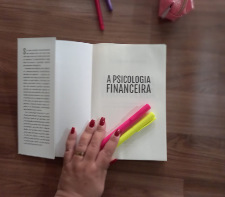 Livro A Psicologia Financeira aberto com marca-textos, representando reflexão e construção consciente de decisões financeiras